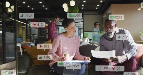 Coworkers reviewing documents and discussing strategy in modern open-plan office lounge