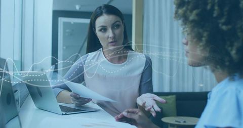 Businesswomen Engaged in Office Meeting Sharing Essential Ideas