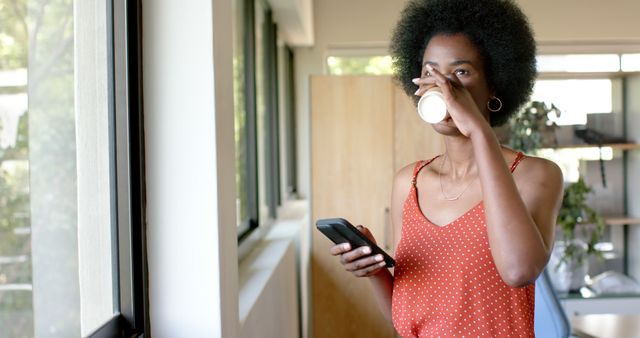 Young Black Woman Drinking Coffee and Using Smartphone in Office - Download Free Stock Images Pikwizard.com