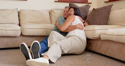 Senior Couple Embracing on Living Room Floor