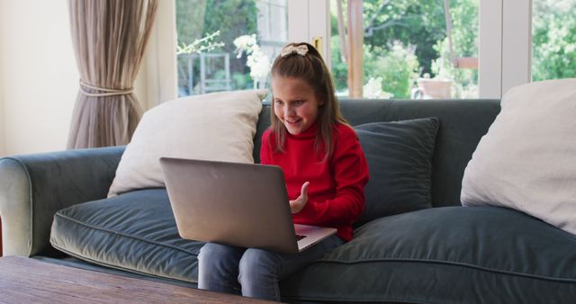 Excited girl video calling on laptop in living room - Download Free Stock Images Pikwizard.com