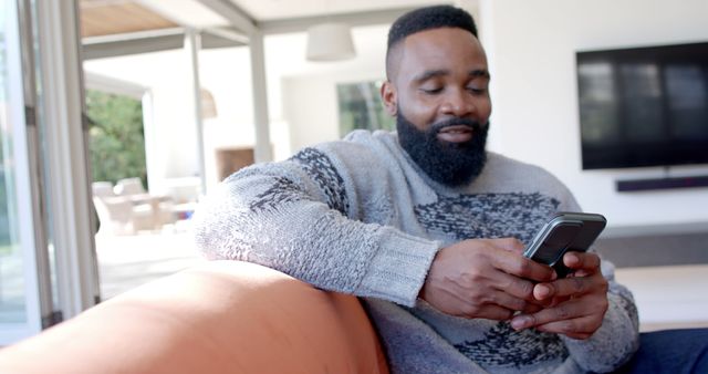 Man Relaxing on Sofa Using Smartphone in Living Room - Download Free Stock Images Pikwizard.com