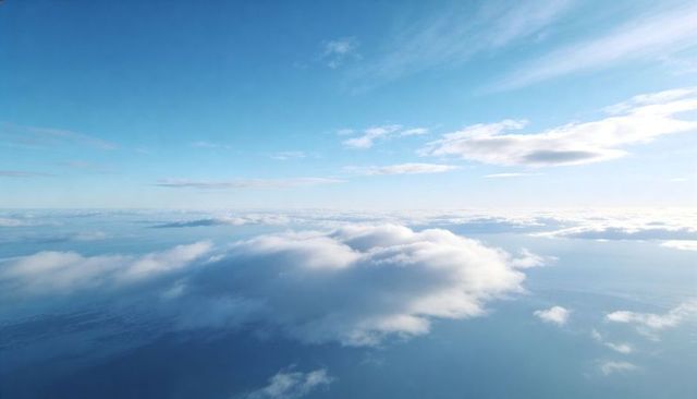 Floating cumulus cloud drifting over coastal ocean with expansive blue sky horizon