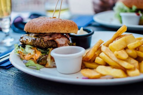 Juicy burger with french fries on outdoor patio table