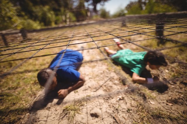Kids crawling under the net during obstacle course in boot camp