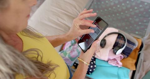 Mature woman using smartphone for digital boarding pass
