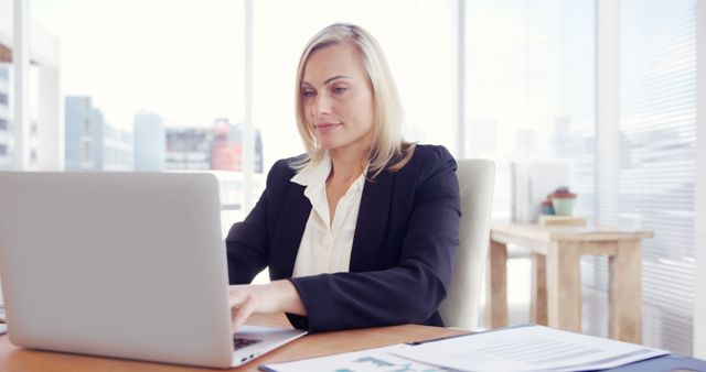 Focused Businesswoman Working on Laptop in Bright Office - Download Free Stock Images Pikwizard.com