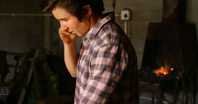 Young Blacksmith Answering Phone in Workshop - Download Free Stock Images Pikwizard.com