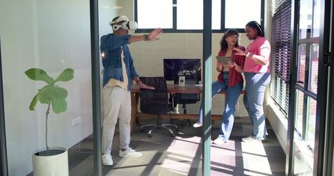 African American Team Testing VR Headset and Collaborating with Tablet in Glass Office