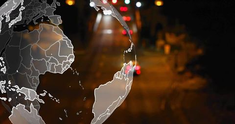 Translucent Globe Showing World Map Overlay over Blurred Urban Night Bokeh