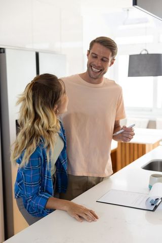 Happy Couple Reviewing Documents in Modern Kitchen Interior