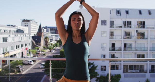 Biracial gender fluid person practicing yoga meditation on roof terrace. staying at home in isolation during quarantine lockdown.