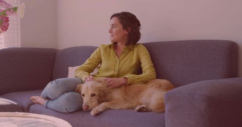 Woman Relaxing at Home with Dog on Cozy Sofa