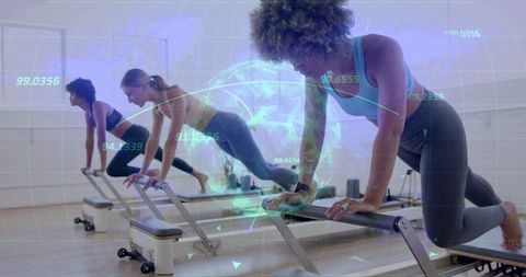 Women Engaging in High-Tech Pilates Reformer Exercise Class