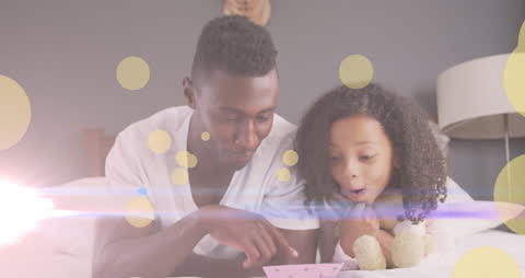 Father and Daughter Sharing Story Time on Bed