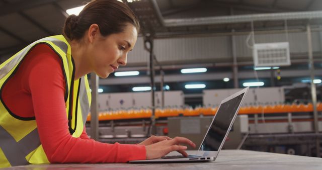 Female factory worker using laptop in industrial environment - Download Free Stock Images Pikwizard.com