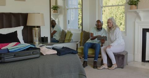 Couple planning wedding with tablet in cozy bedroom setting