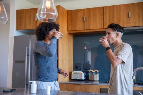 Diverse Male Friends Enjoying Refreshing Drinks in Modern Kitchen