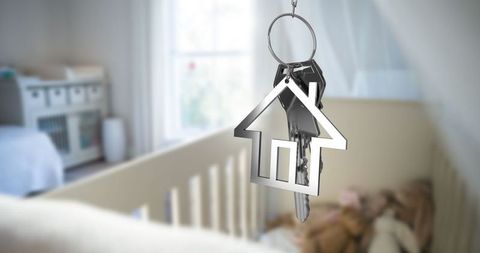 House keychain hanging above adorable baby nursery crib