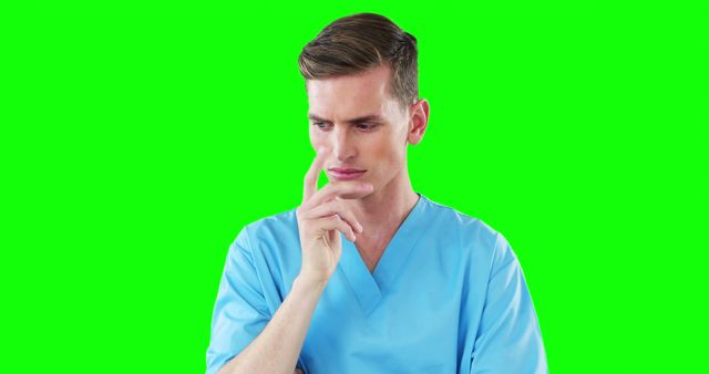 This image features a medical professional dressed in blue scrubs, appearing deep in thought, against a green screen background. It can be used for healthcare, medical, thinking, and decision-making concept materials or adding customized backgrounds.