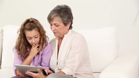 Grandmother and Granddaughter Using Tablet for Learning
