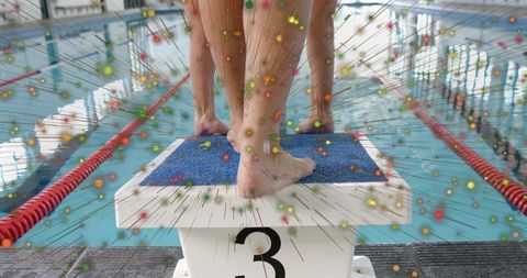 Balancing on starting block 3, bare feet gripping blue pad, swimmer preparing race start