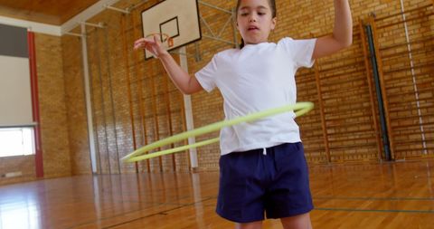 Young Girl Hula Hooping in School Gym