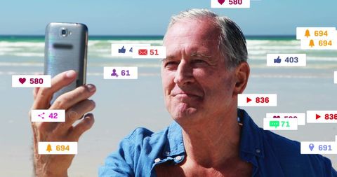 Senior Man Engaging on Social Media at Beach