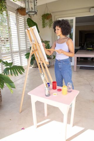 African American Woman Painting in Minimalist Studio