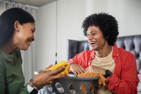 Cheerful Couple Folding Laundry in Cozy Home Environment