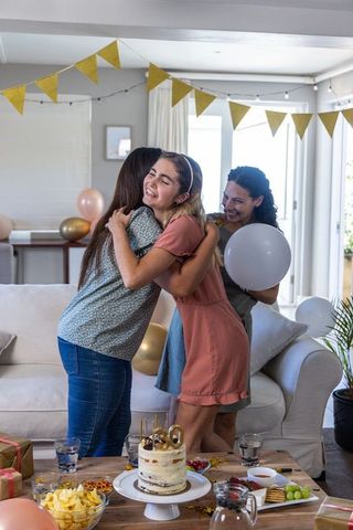 Three friends celebrating 30th birthday with joyful hug