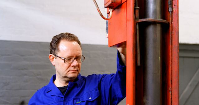 Focused Mechanic Inspecting Car Lift in Auto Repair Shop - Download Free Stock Images Pikwizard.com