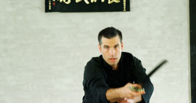 Focused Martial Artist Practicing with Sword in Traditional Dojo - Download Free Stock Images Pikwizard.com