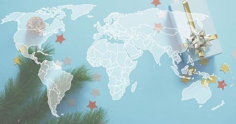 Global holiday flat lay featuring white world map overlay, pastel gift box and pine branch