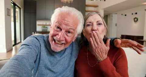 Joyful Senior Couple Taking Selfie in Cozy Living Room