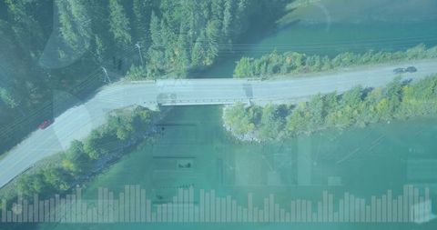 Cars cross bridge over turquoise river in serene mountain forest