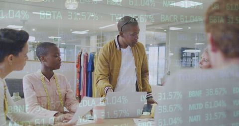 Diverse team collaborating with financial data projections in modern office