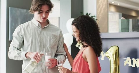 Young Couple Celebrating Anniversary with Champagne at Home