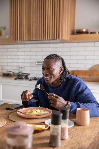 Man Enjoying Breakfast at Home in Warm Kitchen Setting