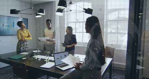 Presenting analytics and strategy by diverse corporate team in glass-walled conference room