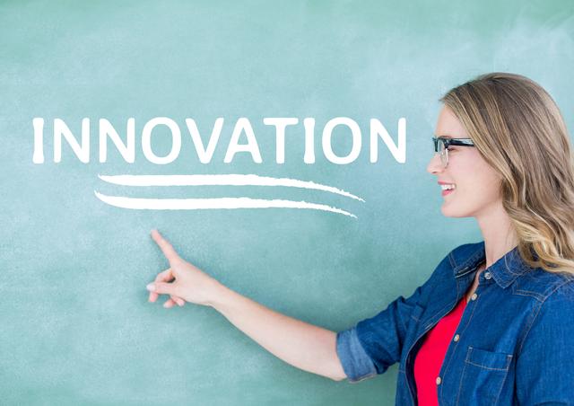 Digital composite image of teacher pointing on chalkboard with text innovation
