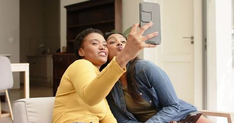 Two Friends Taking Selfie in Cozy Living Room Setting