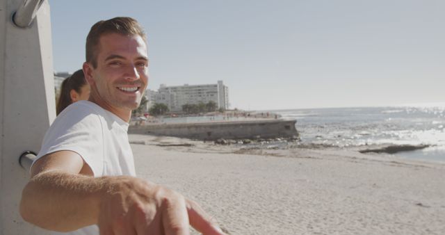 Man smiling at beachside near pier on sunny day - Download Free Stock Images Pikwizard.com