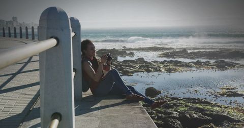 Woman Enjoying Photography on Oceanfront Promenade - Download Free Stock Images Pikwizard.com