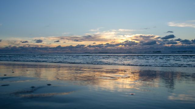 Serene Sunset Over Calm Ocean Waves Reflecting Majestic Clouds - Download Free Stock Photos Pikwizard.com