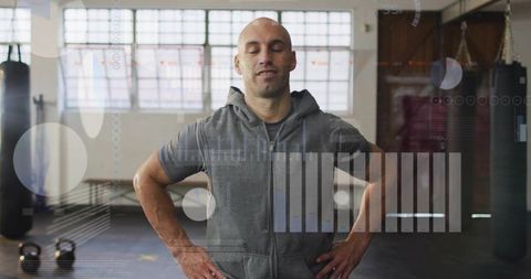 Bald athlete pausing and catching breath in gym with hud fitness data overlay