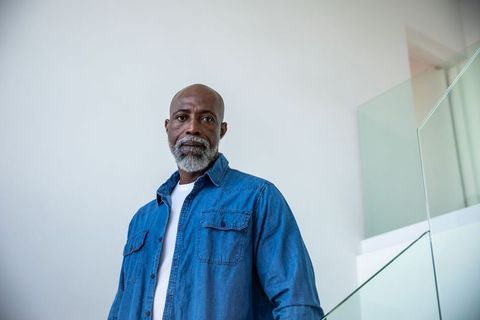 Senior Man Standing on Staircase in Modern Minimalist Interior