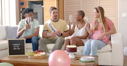 Friends celebrating job success with cake and champagne