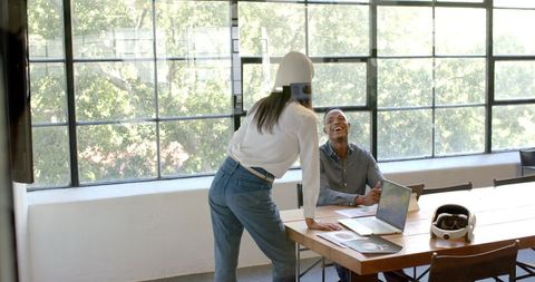 Colleagues Collaborating in Modern Office Setting with Laughs