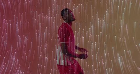 Dynamic athlete dancing amidst digital light streaks